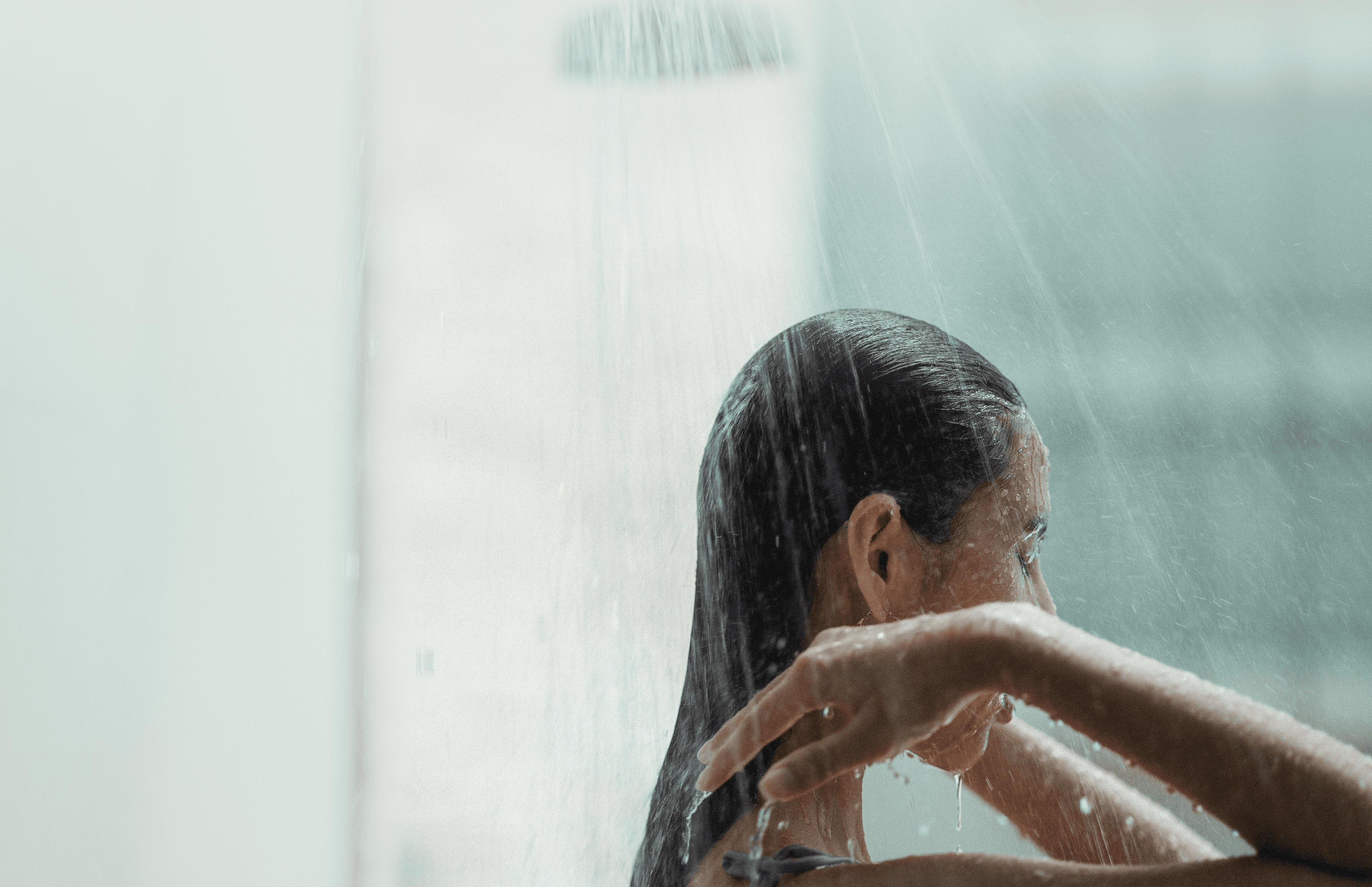 Woman rinsing her hair under a Siren filtered showerhead